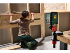 PARKSIDE® Cross Line Laser projecting a red line, used by a person working on a wooden frame.