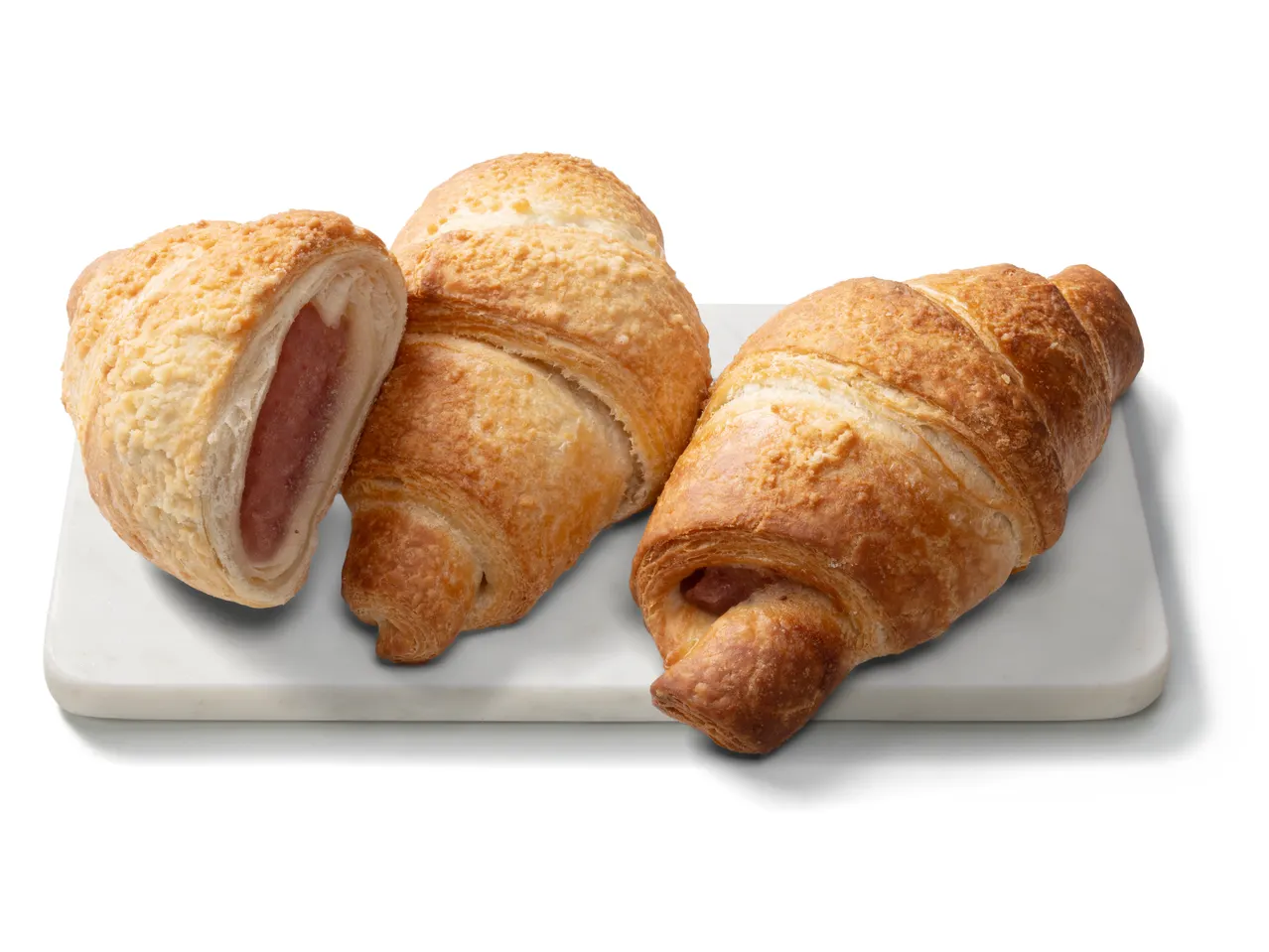 Három epres-joghurtos croissant fehér márványtálcán.