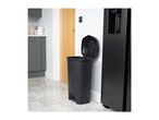 Black kitchen bin with an open lid next to a black fridge-freezer in a modern kitchen.