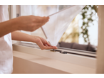 Mâini instalând o plasă anti-insecte LIVARNO la o fereastră.