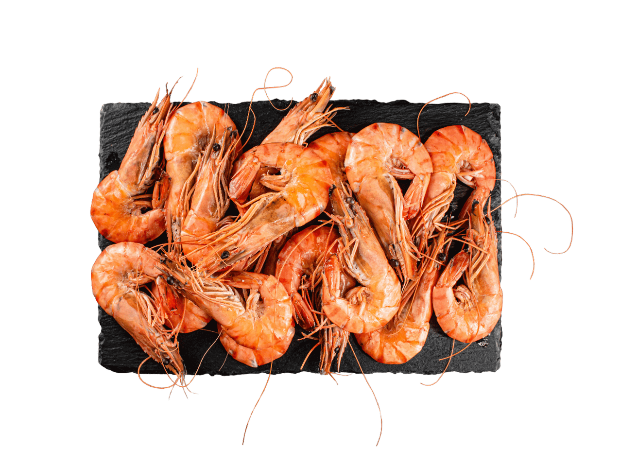 Vārītas garneles uz melnas šīfera plāksnes.