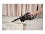 Handheld vacuum cleaner with a crevice nozzle cleaning behind a radiator