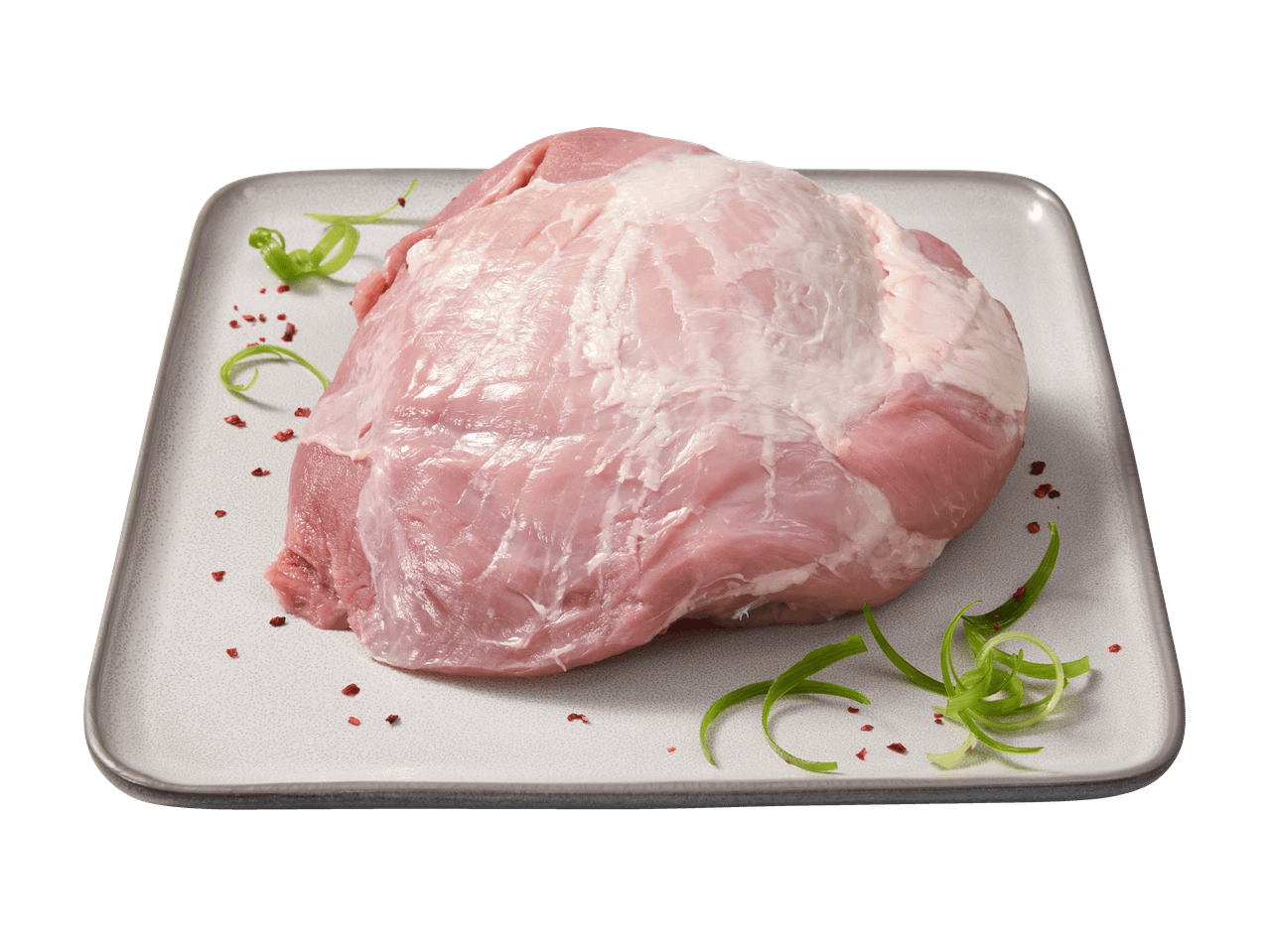 Ein Stück rohes Schweinefleisch auf einem rechteckigen Teller mit grünen Garnituren und Gewürzen.
