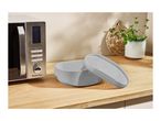 A SilverCrest microwave and a gray microwave steamer on a wooden counter.