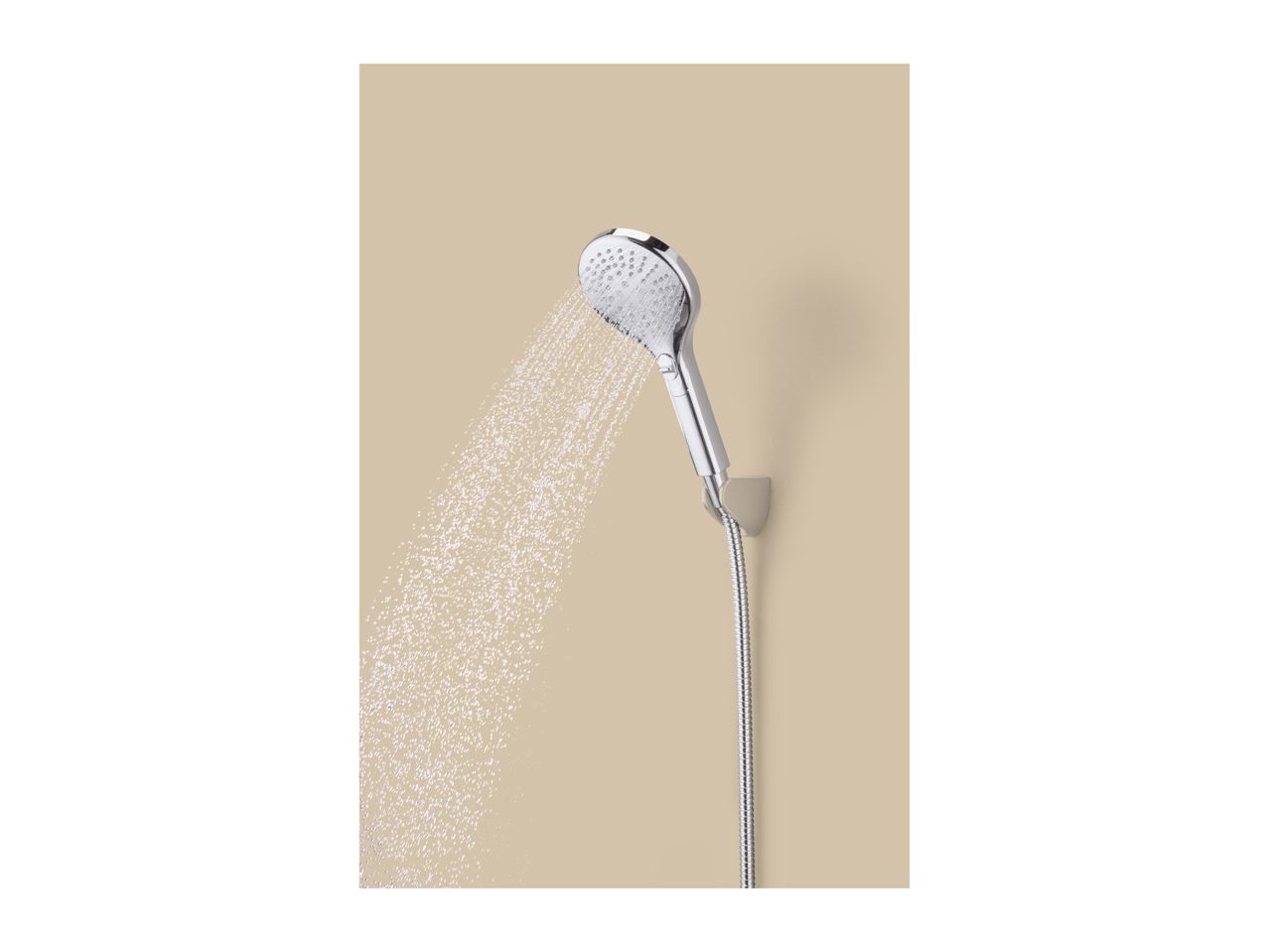 A chrome shower head spraying water, mounted on a beige wall.