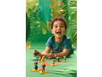 Criança feliz a brincar com figuras de cães e dinossauros num cenário com tema de selva.