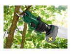 A person wearing gloves uses a green electric pruning shear to cut a tree branch.