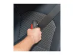 Hand holding a seatbelt cutter and window breaker against a car seat