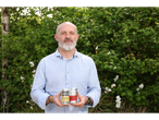 Man holding two cans of Steeper Culture kombucha, one ginger & lemon and one cherry lime.