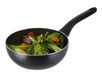 Black frying pan filled with stir-fried vegetables including bok choy, asparagus, and tomatoes.