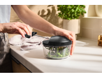 Pessoa a usar um picador universal SILVERCREST para picar ervas numa bancada de cozinha.