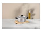 Stainless steel pot with glass lid on a wooden board, with garlic and olive oil.