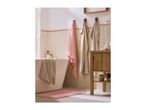 Bathroom with a bathtub, pink bath mat, and towels hanging on wall hooks.