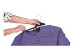 Hands placing a purple cardigan onto a black clothes hanger.
