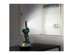A cordless work light illuminates an open fuse box, with a battery pack visible below.