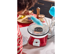 Person making blue cotton candy with a cotton candy machine on a white table