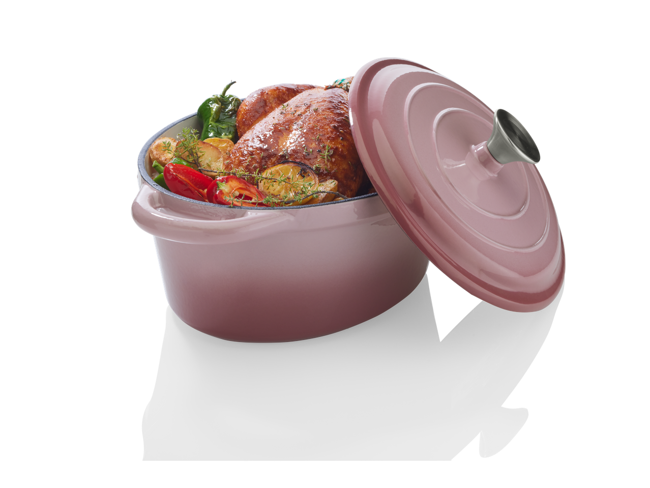 Frango assado e legumes em uma panela de ferro fundido rosa.