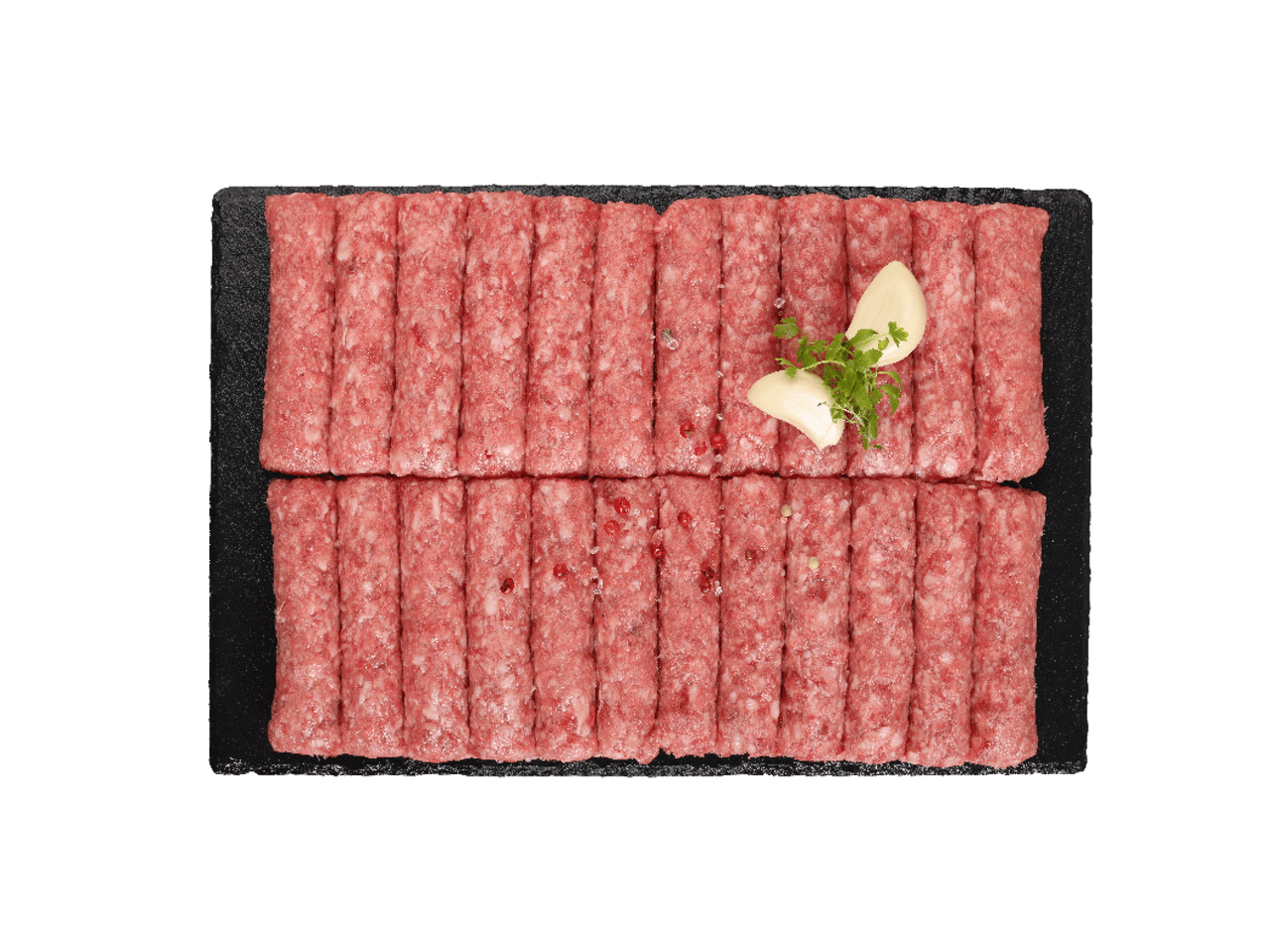 Sveži ćevapi na crnoj tacni, ukrašeni belim lukom i peršunom.