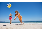 Two women playing beach volleyball on the sand.