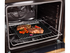 Placa de ferro fundido SILVERCREST no forno com carne e vegetais grelhados.