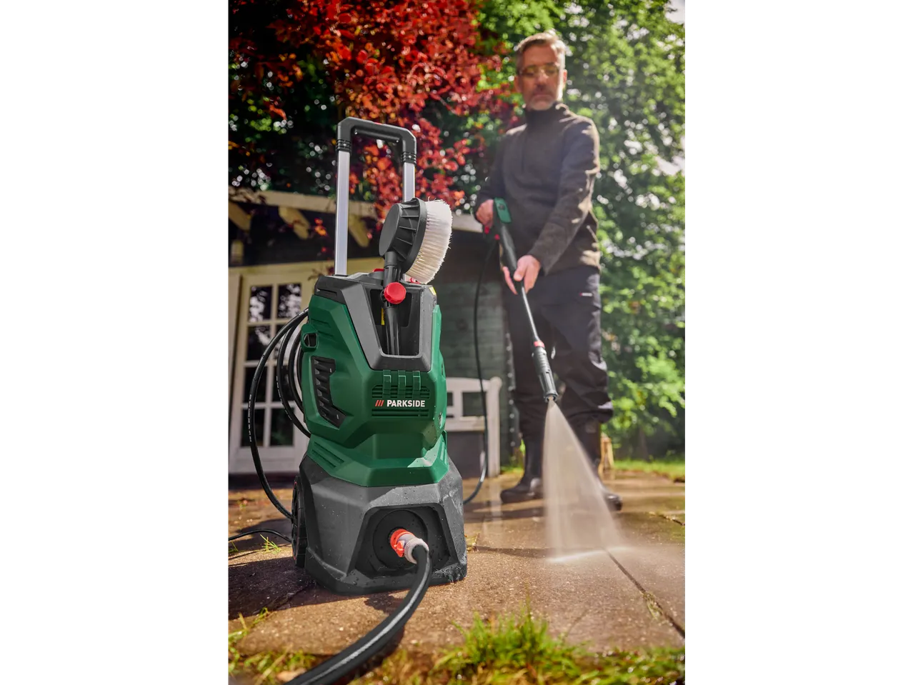PARKSIDE pressure washer and man cleaning a patio