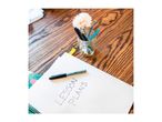 A notebook with 'LESSON PLANS' written on it, a pen, and a jar of pens and a flower.