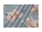 Close-up of a light blue fabric with a floral pattern of large, light pink flowers.