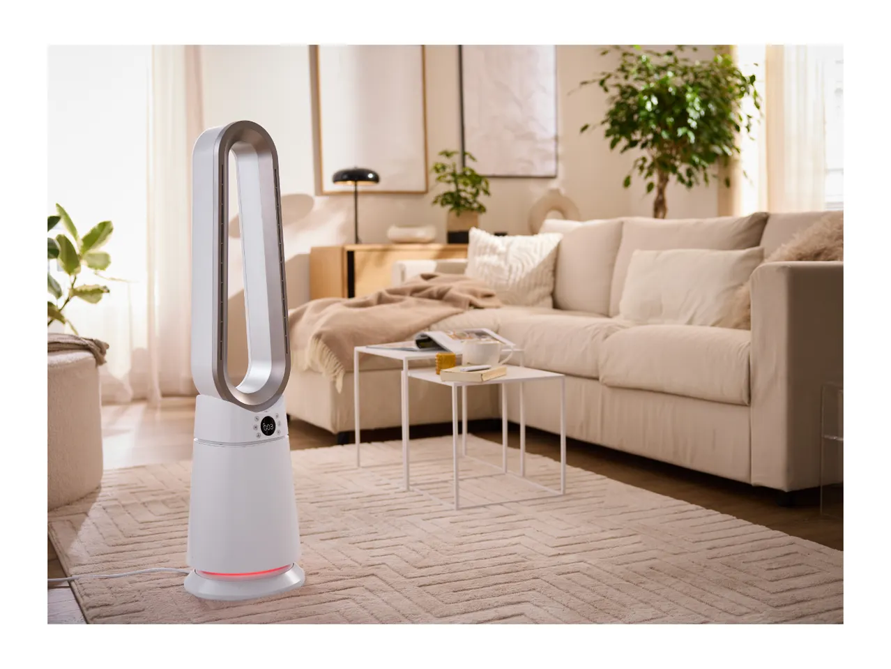 White air purifier in a modern living room with a beige sofa and rug.