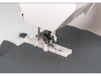 Singer® sewing machine with buttonhole foot, button, and grey fabric.