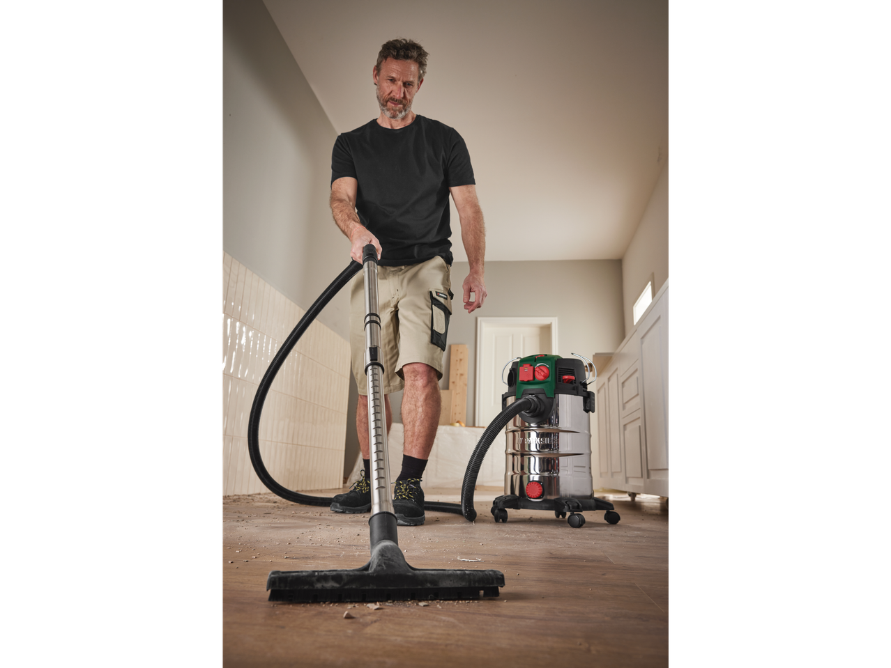 Man cleaning floor with a Parkside industrial vacuum cleaner.