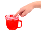 Hand pressing down on the red Sistema microwave soup mug with a clear lid.