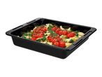 Black baking tray with pasta, spinach, and cherry tomatoes on the vine.