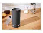 A SilverCrest coffee grinder with coffee beans, a French press, and sugar on a wooden counter.