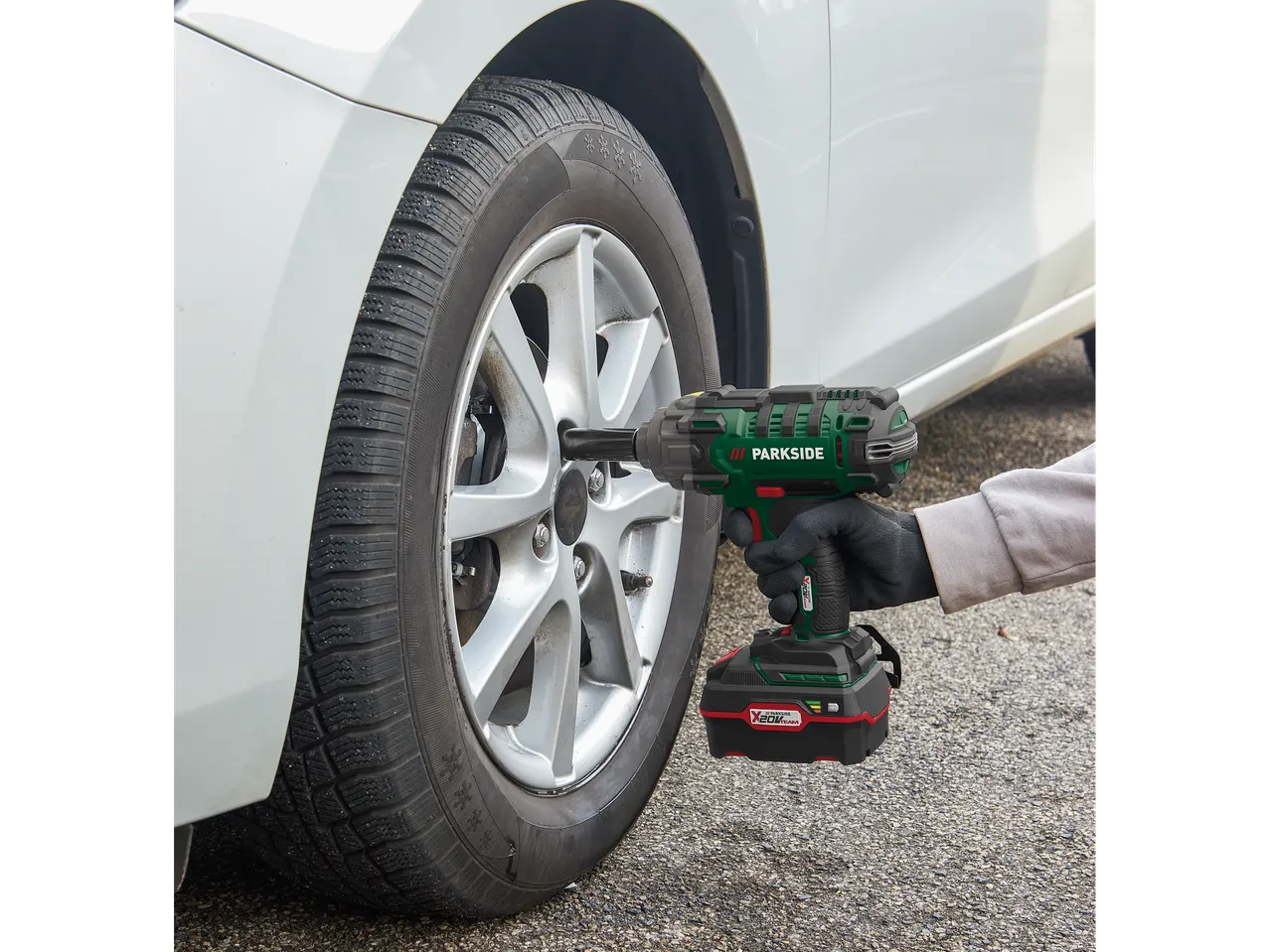 Parkside® akumulatorski udarni odvijač koji se koristi za promenu gume na automobilu.