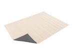 Cream-colored rectangular bath mat with a dark gray non-slip backing visible at one corner.