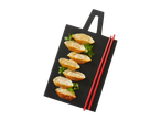 Gyoza frita em uma tábua preta com pauzinhos vermelhos.