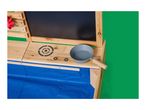Wooden play kitchen with a chalkboard, cooking hob, and a grey pot.