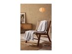 A light gray blanket draped over a wooden and wicker chair in a cozy room.