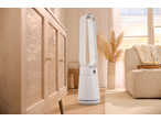 A white air purifier in a living room with a wooden cabinet and a beige sofa.