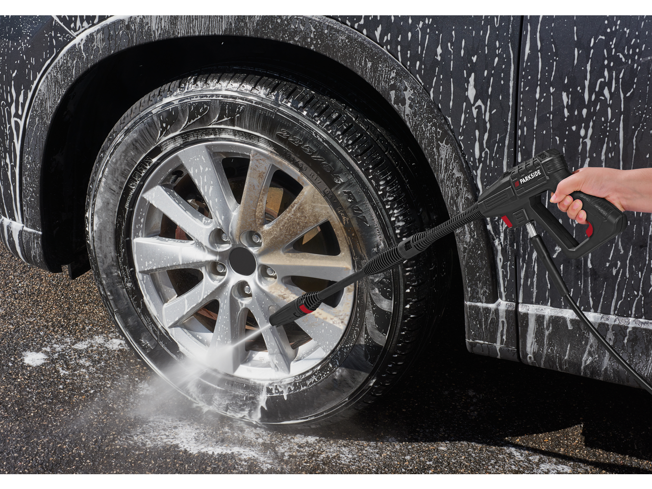 PARKSIDE pressure washer cleaning a dirty car wheel with foam.