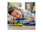A child playing with toy boats and figures on a wooden floor.