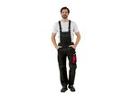 Man in black work overalls with red accents and a white t-shirt.