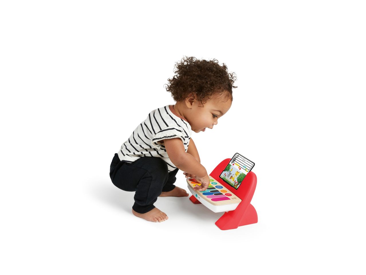 Toddler playing with a colorful toy piano with sheet music showing a giraffe.