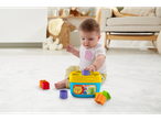 Baby playing with a Fisher-Price shape sorter on a white rug.