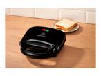 Black sandwich maker on a wooden counter with two slices of bread on a plate.