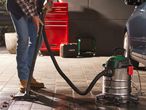 Man using a Parkside wet/dry vacuum cleaner on a patio.