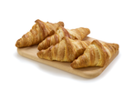 Croissants dorés sur une planche en bois.