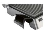 Close-up of an electric grill with a removable drip tray and a release button.