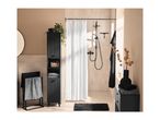 Modern bathroom with black storage cabinet, shower, and towels in black and white patterns.