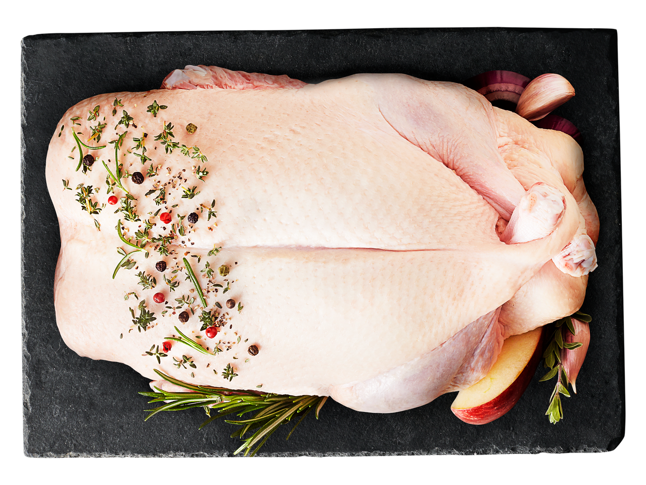 Jēla pīle ar garšvielām, sīpoliem un ābolu uz melna dēlīša.